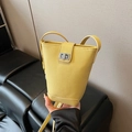 Bright yellow bucket crossbody bag in lychee texture with silver twist lock and slim strap - With Charm / Yellow