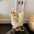 Off-white lychee grain leather bucket bag with silver twist lock and doll charm - White with Pendant