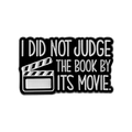 Black enamel book pin with 'I DID NOT JUDGE THE BOOK BY ITS MOVIE' quote and clapperboard - Book Over Movie Style (QHXZ3802)