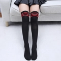 Gros plan sur les chaussettes hautes noires en coton avec trois rayures rouges sportives - Taille unique / Noir avec trois bandes rouges
