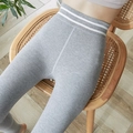 Graue High-Waist Yoga-Leggings mit weißen Streifen am Bund auf einem Holzstuhl - Einheitsgröße / Hellgrau