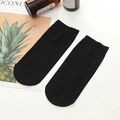 Sheer black ankle socks with ribbed cuffs shown in a minimalist flat lay arrangement - One Size / Black