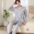 Silver-grey silk satin men's long-sleeve pajama set with brown piping on bed - Light Gray