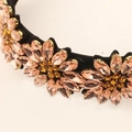 Pink rhinestone flower headband with black base and golden crystal claw settings - Champagne