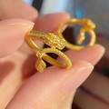 Nahaufnahme eines goldenen Drachenrings mit Schuppen, roten Augen und Blattanhänger - Einstellbar Offen / Gold