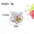 Trust Your Gut enamel pin with yellow lily and large intestine design on white tray - Intestine Floral Trust Style / Anatomical Intestine