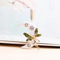 Detailed close-up of a crescent moon fairy brooch with green glitter wings and stars - Milky White