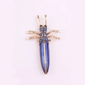 Golden insect brooch with blue crystals and opal effect stone in a centered top view - Blue