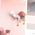 Détail d'une broche alpaga en émail avec strass et une chaîne décorative dorée - Blanc