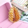Elegant maple leaf brooch with amber drip oil finish and rhinestones in gold plating - Brown