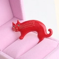 Broche chat rouge brillant aux contours dorés sur un support de boîte à bijoux rose - Rouge