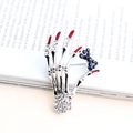 Silver skeleton hand brooch with white diamonds, red nails and blue bow detail - Silver