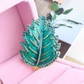 Spilla a foglia in smalto blu e verde con strass blu in una scatola rosa - Blu Pavone