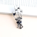 Detailed view of vintage silver skeleton hand brooch with blue rhinestones and engraving - Antique Silver Skeleton Hand / Antique Silver
