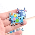 Macro-opname van een kleurrijke emaille koeienbroche met heldere stippen - Blauw