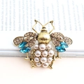 Vintage gold bee brooch featuring brown rhinestones, blue crystals, and pearl accents - Antique Gold And Blue