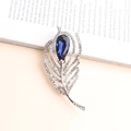 Elegant silver feather brooch featuring a large pear-cut dark blue gemstone with zircons - Silver
