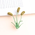 Golden wheat ears brooch with green leaves on a vintage book background - Gold