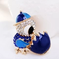 Macro shot of bird brooch with blue crystals and enamel detailing on gold alloy - Blue White Bird (Style 10)