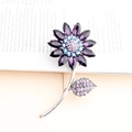 Lila Sonnenblumen Kristall-Brosche mit blauer Mitte auf vintage Buchseiten - Dunkelviolett