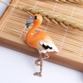 Exquisite flamingo brooch with orange enamel and champagne rhinestones on bamboo tray - Orange