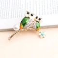 Detail of owl brooch with green enamel wings, rhinestones and a white pearl on a branch - Green Owls On Branch Style (245)