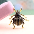 Beetle animal brooch featuring black enamel and rhinestones on a gold alloy base - Black