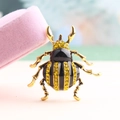 Charming beetle brooch with black enamel and yellow rhinestones in a gold-tone finish - Yellow