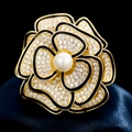 Elegante spilla a camelia dorata con smalto nero, cristalli bianchi e una grande perla centrale - Oro