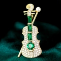 Elegant gold violin brooch with green emerald stones and pearl on dark velvet - Tb574