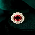 Makro-Detail einer ovalen Rubin-Brosche mit Diamant-Halo auf grünem Samt - TD147 Rot