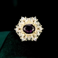 Makroaufnahme von Vintage-Goldring mit lila ovalem Edelstein und floralem Heiligenschein - TB839 / Lila