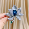 Luxuriöse Blumenbrosche mit blauem Kristall in Birnenform und funkelnden Blüten - Weiß