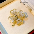 Makroaufnahme der goldenen Kleeblatt-Brosche mit Zirkonia und Nummer 5, Größe 2.7x2.3cm - B751 Weiß