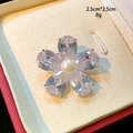 Detail of five-petal flower brooch with emerald stones and central pearl on a gift box - Silver Five-Petal Flower Pearl Style (D115)