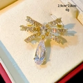 Nahaufnahme einer Schleifen-Brosche mit Zirkon-Inlay und einem Wassertropfen-Anhänger - Transparenter Schleifenstil (B742)