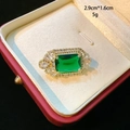 Close-up of a vintage emerald-cut green gemstone brooch in a luxury gift box - Green