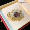 Detailansicht der Luxus-Blumenbrosche mit lila Edelstein und Kristallen in Geschenkbox - Quadratischer Violetter Edelstein Stil (D024)