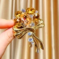 Elegant gold bow brooch featuring amber oval crystals and sparkling rhinestones for suits - Ribbon Bouquet Style (B1717) / Gold/Amber