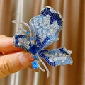 Luxuriöse Schmetterlingsbrosche mit blauen Zirkonia und mikroversetzten Kristallen in der Hand - Blau Weiß Gradient Schmetterling Stil (B1870)