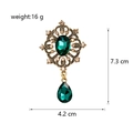 Detailed view of vintage gold flower brooch with emerald green stone and crystal droplets - Antique Gold Base Green Gemstone Style (C045-A)
