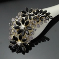 Macro view of floral brooch with black marquise stones and purple rhinestones on gold base - Black and Gold (B026-B)