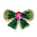 Elegante broche de lazo dorado con cristal rosa y alas de pedrería verde esmeralda - A064-a