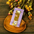 Close-up of golden hollow metal bookmark with silk tassel and floral gift card - Cake and Teapot Design (T01042625)