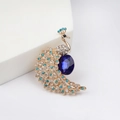 Dettaglio ravvicinato di una spilla a pavone dorata con cristalli blu scuro e strass bianchi - Oro (XZ20-003-2kc Oro)