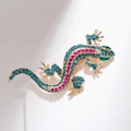Vintage lizard brooch with colorful rhinestones on a gold base against white background - KC Gold Green Rhinestone