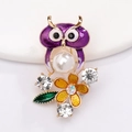 Détail d'une broche hibou dorée avec émail violet et une grande perle blanche - Xz047
