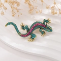 Macro view of colorful lizard brooch with blue and pink rhinestones on golden metal - Antique Gold Green Zircon