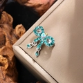 Macro shot of retro bow brooch with emerald rhinestones and iridescent centerpiece - Silver with Green Zircon