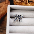 Détail d'une broche nœud argentée avec strass bleu foncé et reflets AB étincelants - Argent Noir